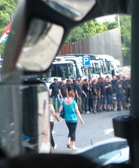© lukastagwerker eine gruppe uniformierter securities aus dem busfenster